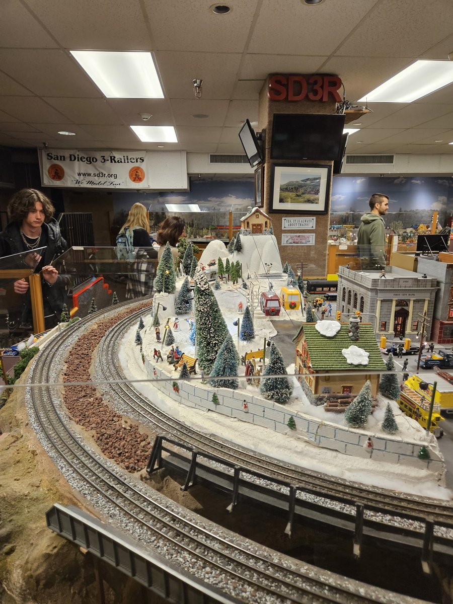 Detailed model railroad layout at Balboa Park, showing miniature mountains, trees and a city with trains running through it