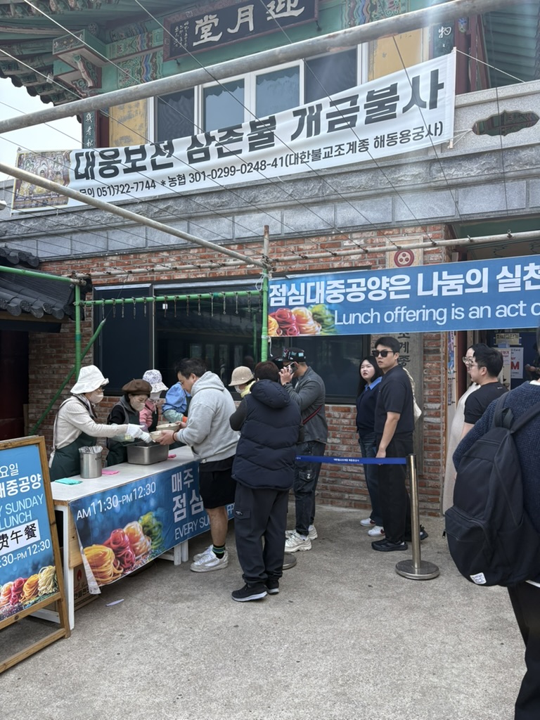 Queue for the free Sunday lunch at Haedong Yonggungsa Temple with sign in English