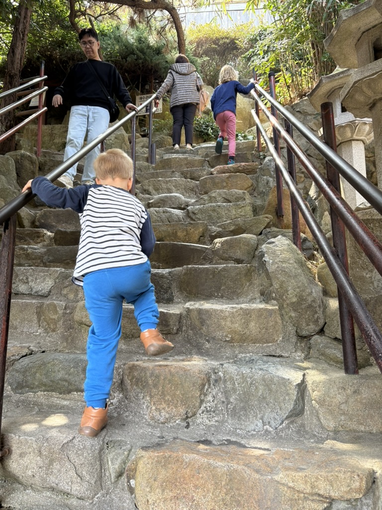 Young kids climbing the stone stairs at Haedong Yonggungsa Temple