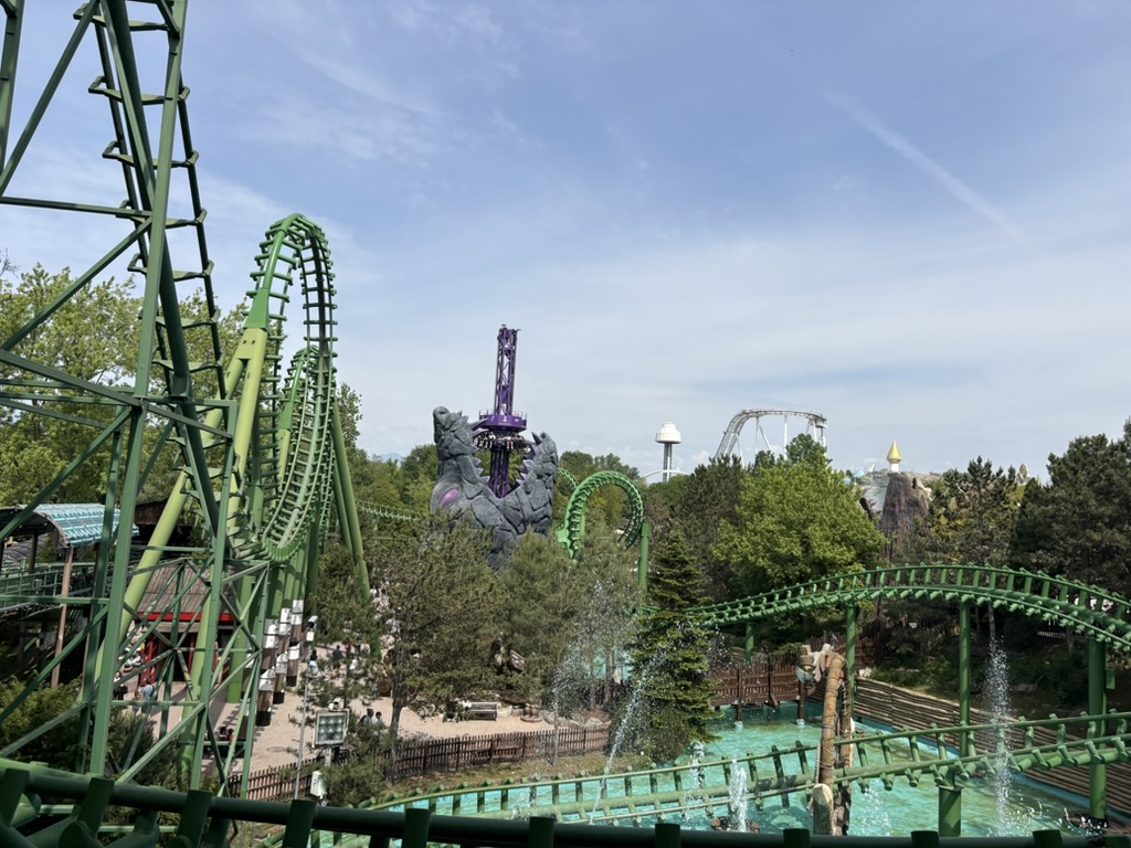 Gardaland park overview showing green coasters, purple drop tower, and water ride area
