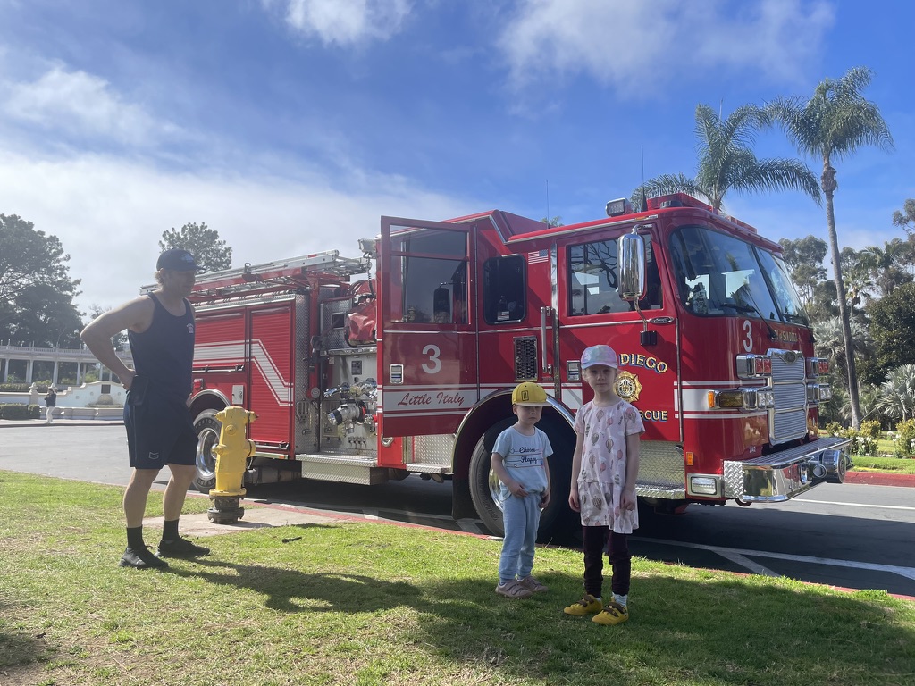 Two young children standing in front of a San Diego Fire Rescue truck in Balboa Park