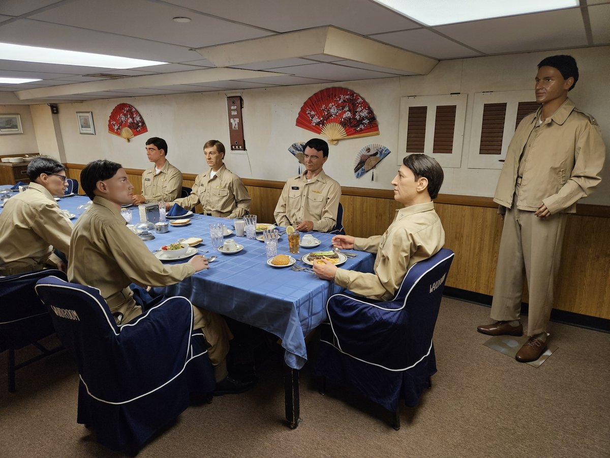 The officers' wardroom aboard USS Midway, preserved as it was when operational, with uniformed mannequins seated around the dining table