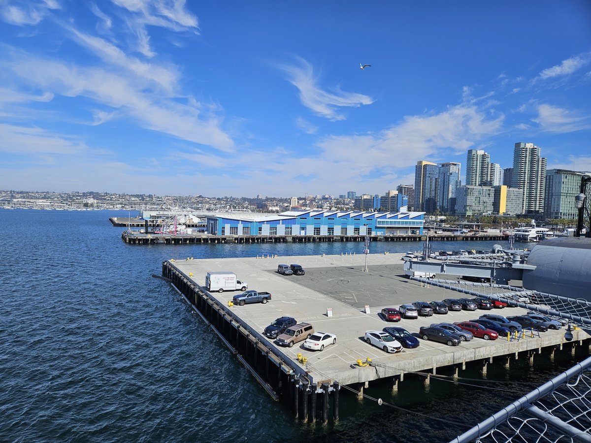 View from the USS Midway flight deck looking out over San Diego Bay, with the downtown waterfront and skyline in the distance
