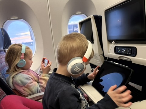 Kids with headphones on the overnight Asiana flight to Seoul