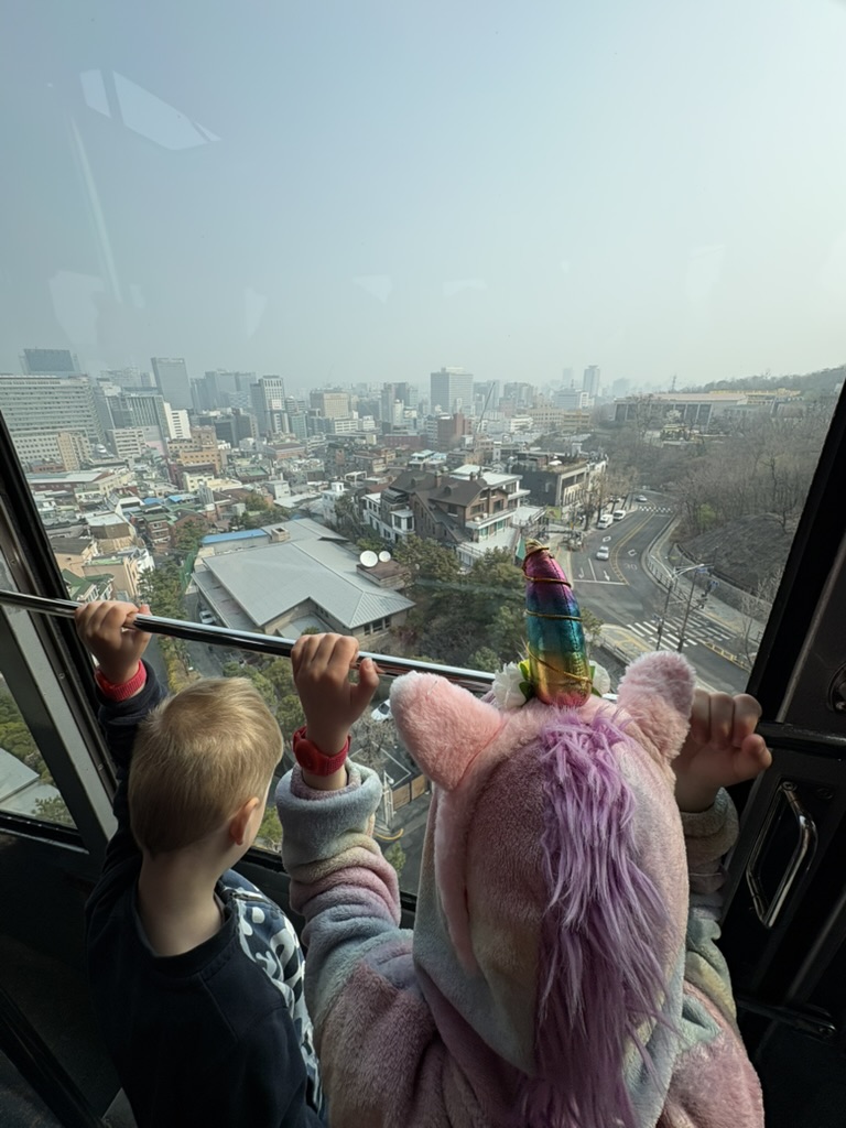 Kids looking out of the Namsan cable car over Seoul