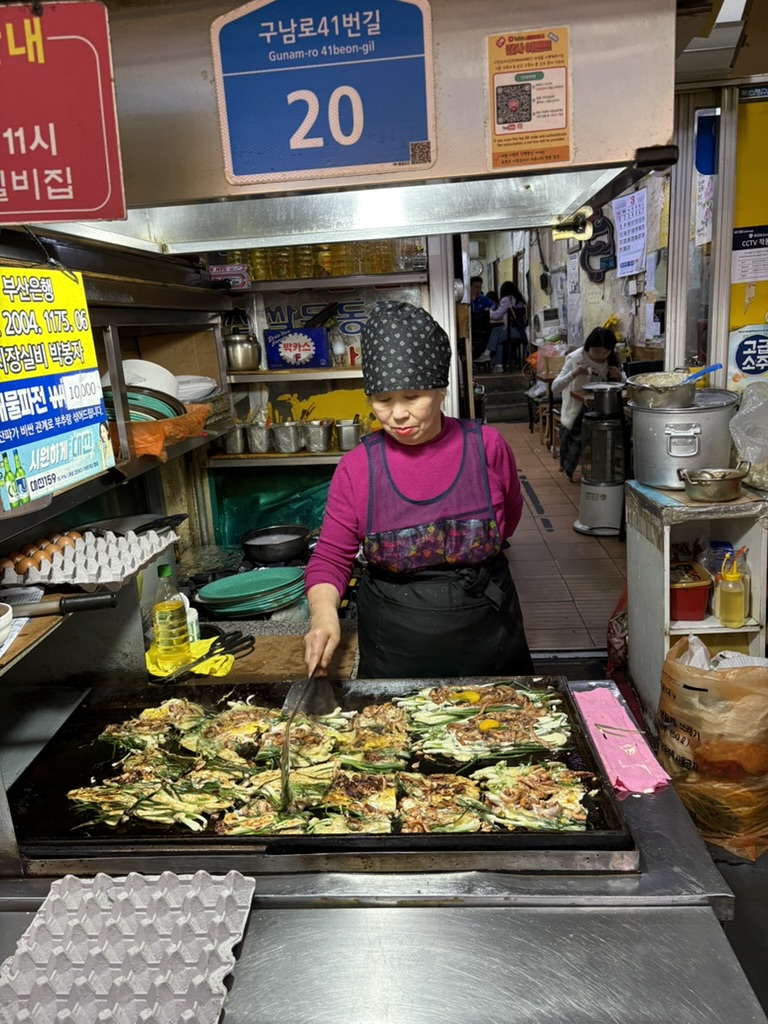 Night market vendor cooking pajeon on a hot griddle, Haeundae