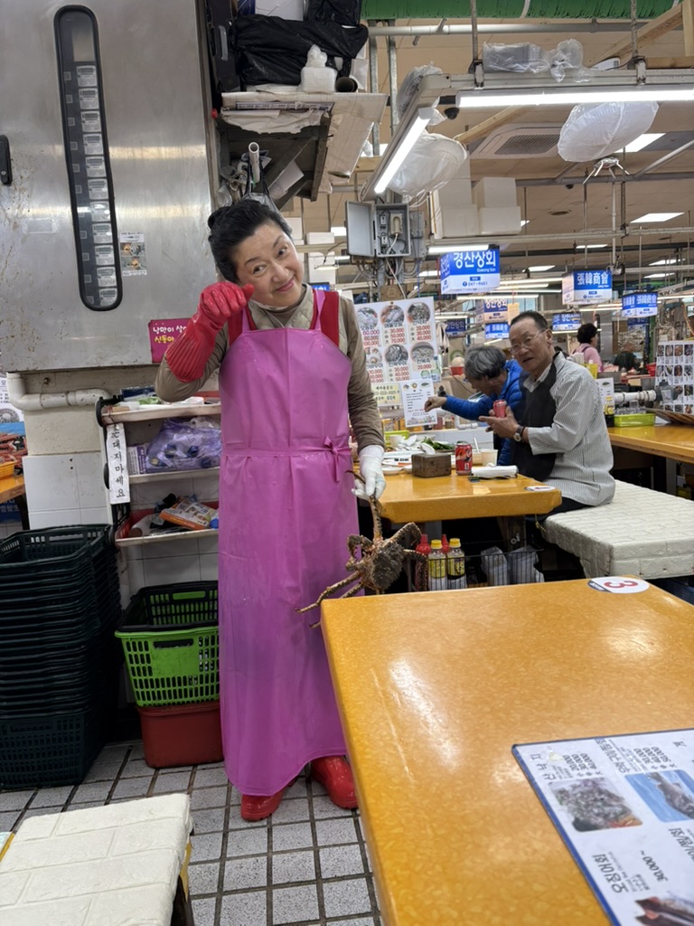 Jagalchi Market vendor holding a large crab upstairs in the restaurant